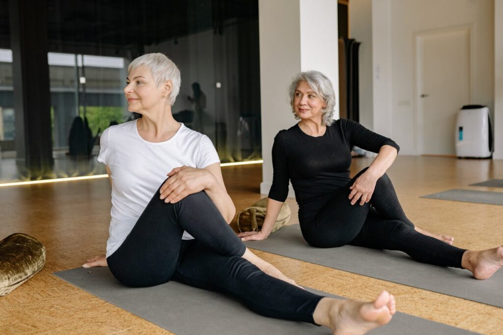 two elderly ladies stretching on a mat