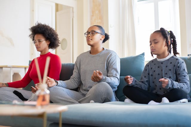 A group of people sitting on a couch meditating