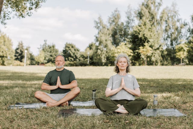 A couple meditating in a park