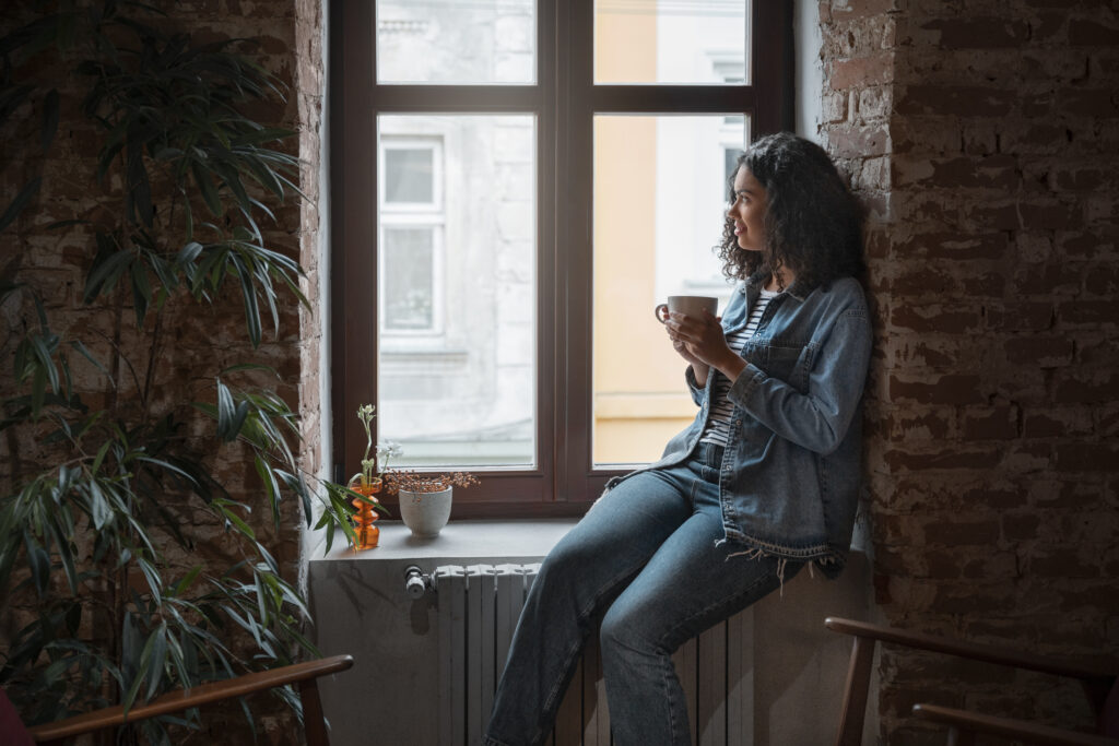 Woman drinking tea by a window
